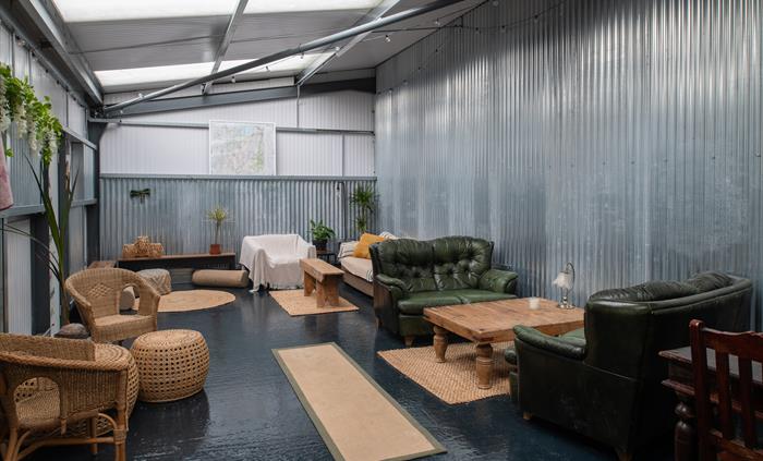 Inside a communal shed with sofas, tables, rustic furnishings and games room